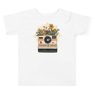 white t-shirt with camera and flowers, reads: focus on the good